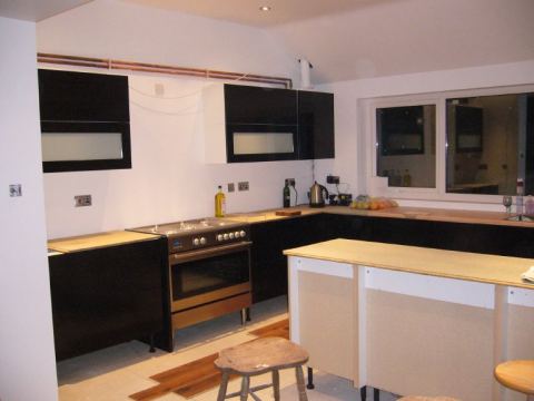 temporary kitchen, complete with bare chipboard worktops.. they'll be there till winter then.
